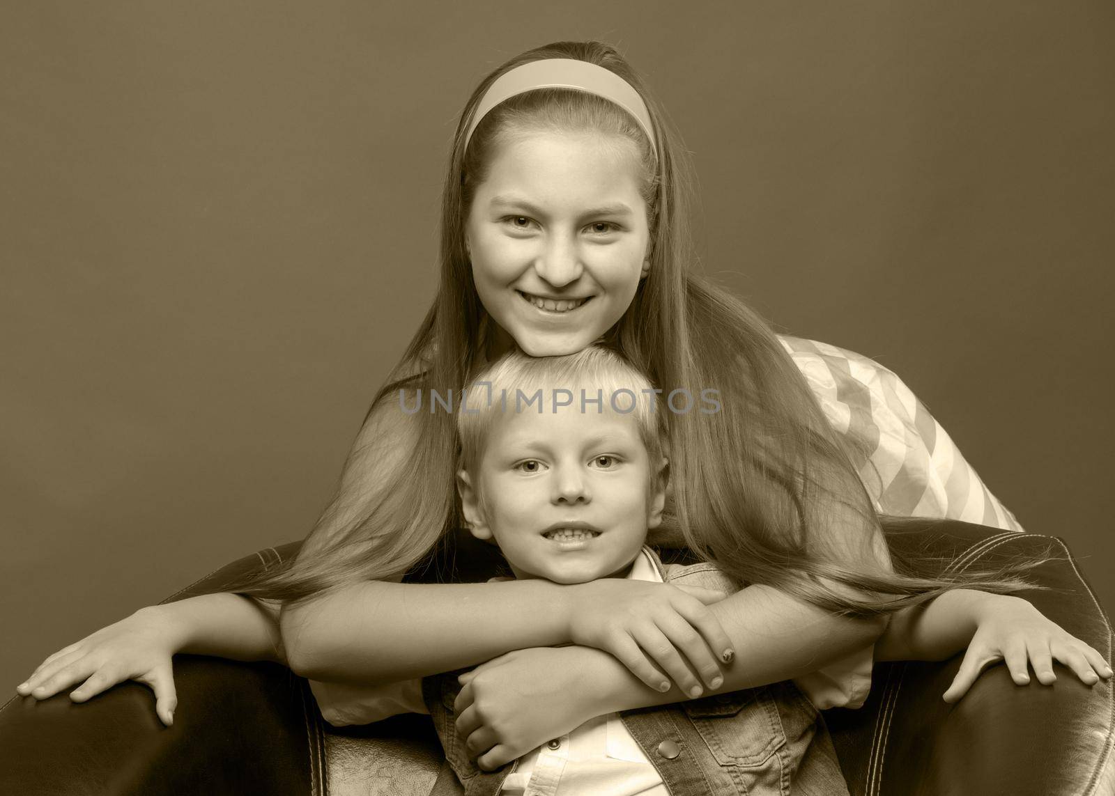 A teenage girl with her younger brother. studio photo session. The concept of family happiness.