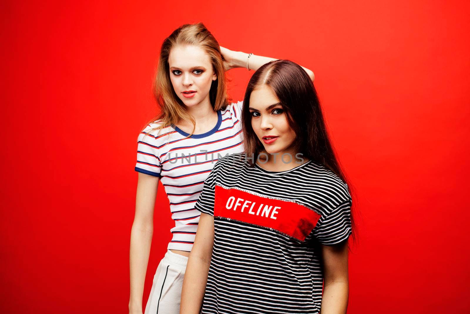 two best friends teenage girls together having fun, posing emotional on red background, besties happy smiling, lifestyle people concept by JordanJ