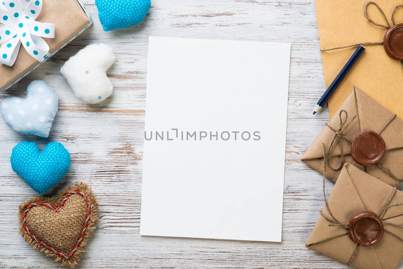 Flat lay cute composition with handmade fabric heart. White paper and retro mail envelopes on wooden table. Happy birthday or anniversary congratulation. Romantic message template with copy space