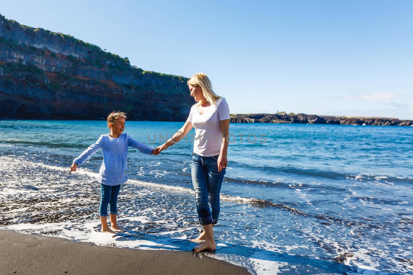 Family holiday on Tenerife, Spain. Mother with children outdoors on ocean. Portrait travel tourists - mom with kids. Positive human emotions, active lifestyles. Happy young family on sea beach by Andelov13