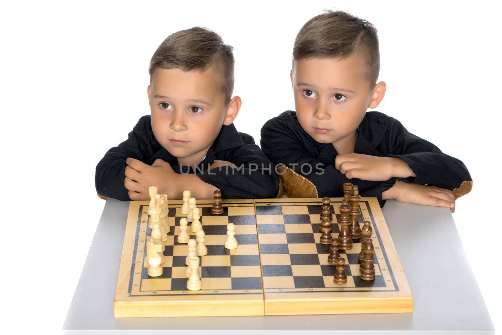 Two brothers are playing chess at home. Game, education, lifestyle concept.Isolated on white background
