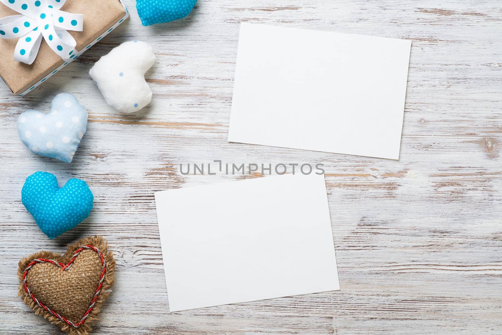 Flat lay composition with fabric love hearts and ribbon. Blank sheet of white paper on vintage wooden table. Declaration of love letter. Saint Valentine's day congratulation. Romantic event invitation