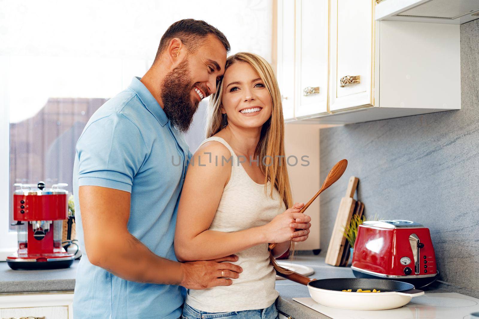 Young loving couple cooking together in kitchen at home