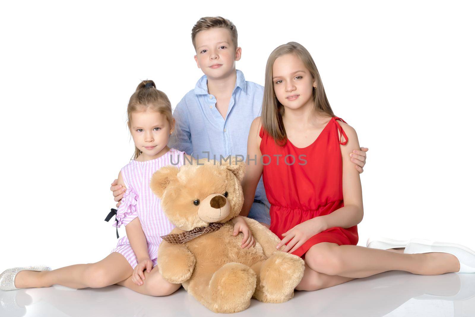 Brother and two sisters with a teddy bear by kolesnikov_studio