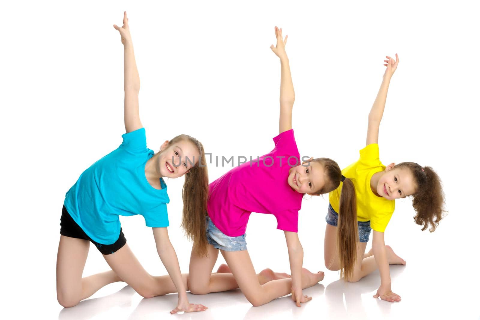 A group of cheerful little girls-gymnasts performing various gymnastic and fitness exercises. The concept of an active way of life, a happy childhood. Isolated on white background.