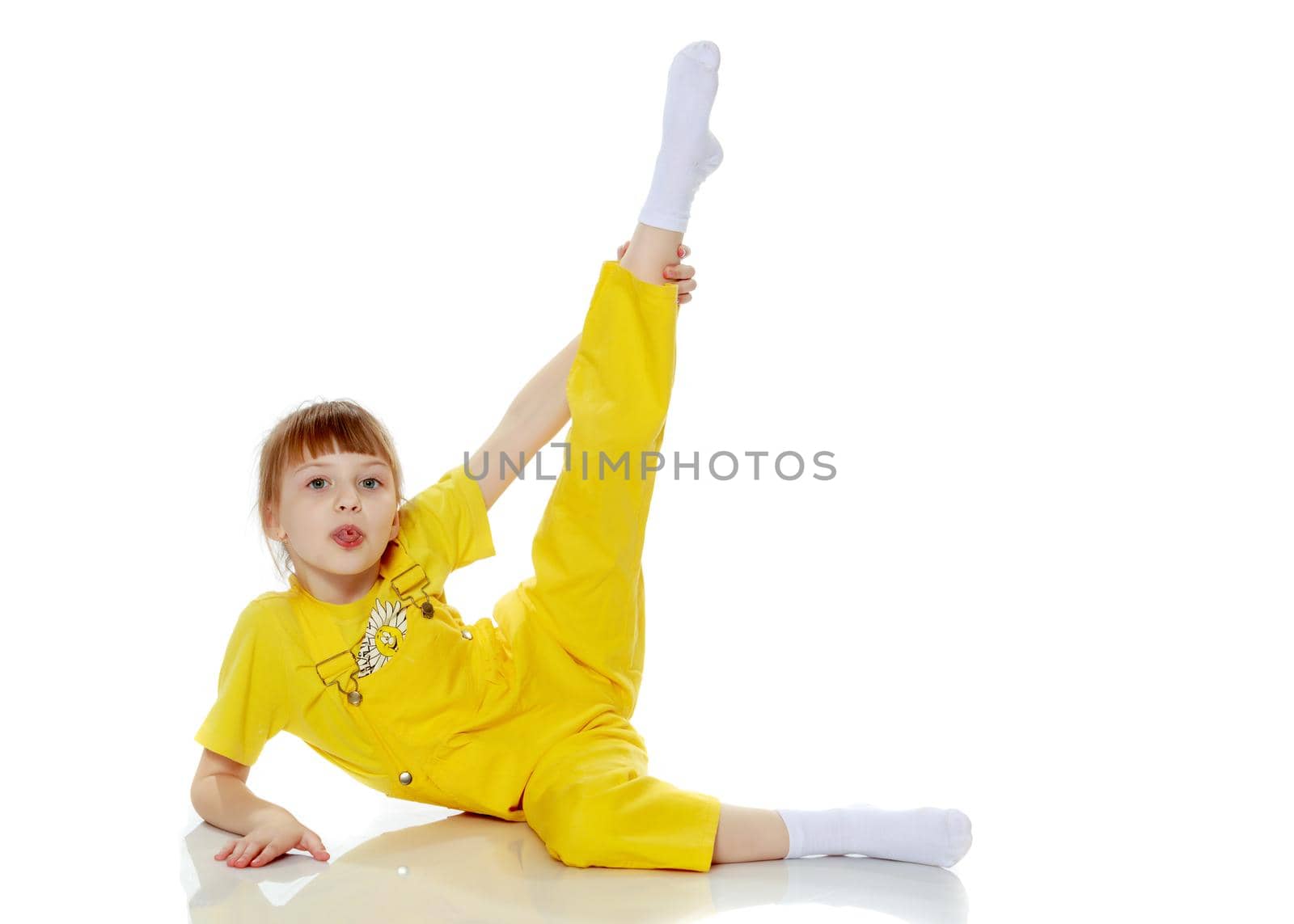 Girl with a short bangs on her head and bright yellow overalls.She crouched down on the white advertising banner.