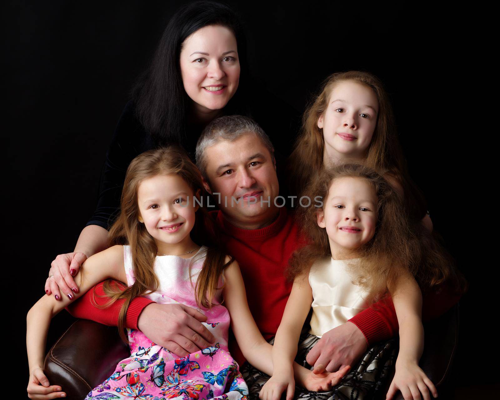 Big happy family with children on a black background. Concepts people, holidays, happiness, harmonious development of the child in the family.