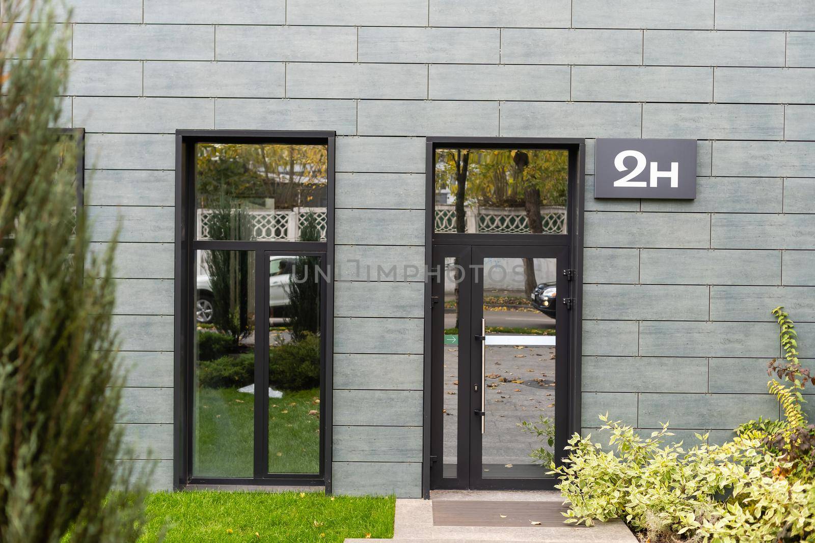 The front door of a office block, reflecting buildings in the glass.