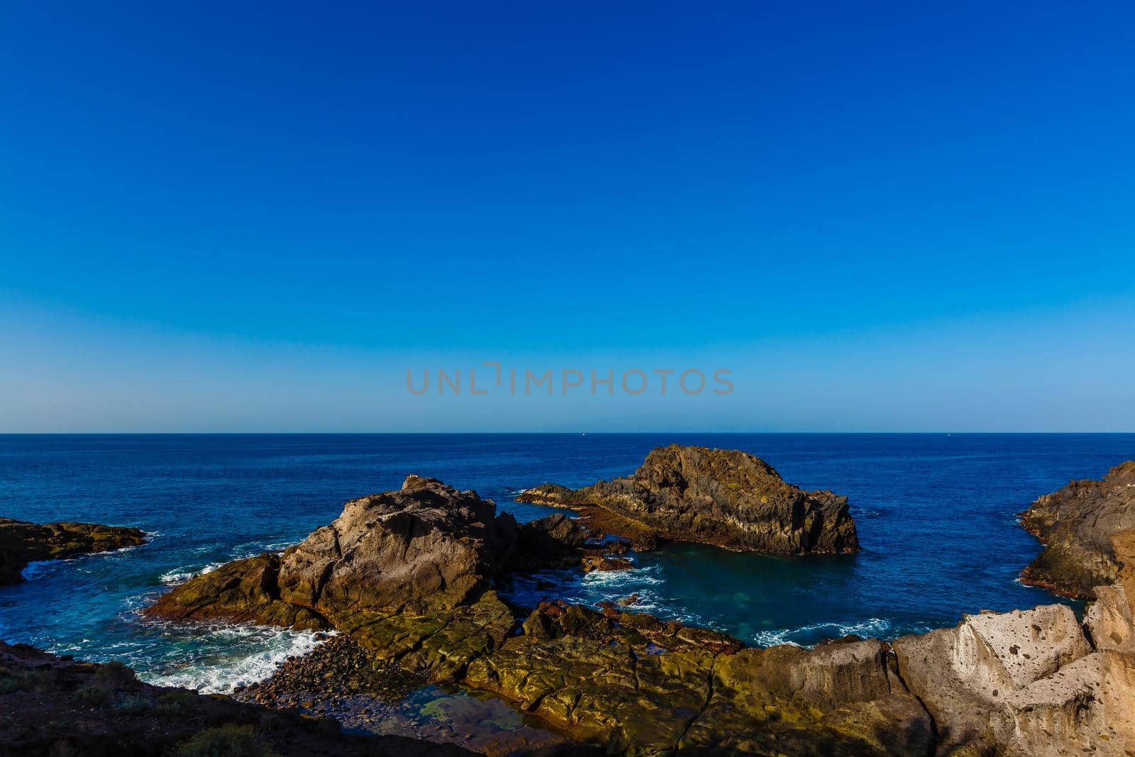 Evening scene on sea, stones, calm ocean.