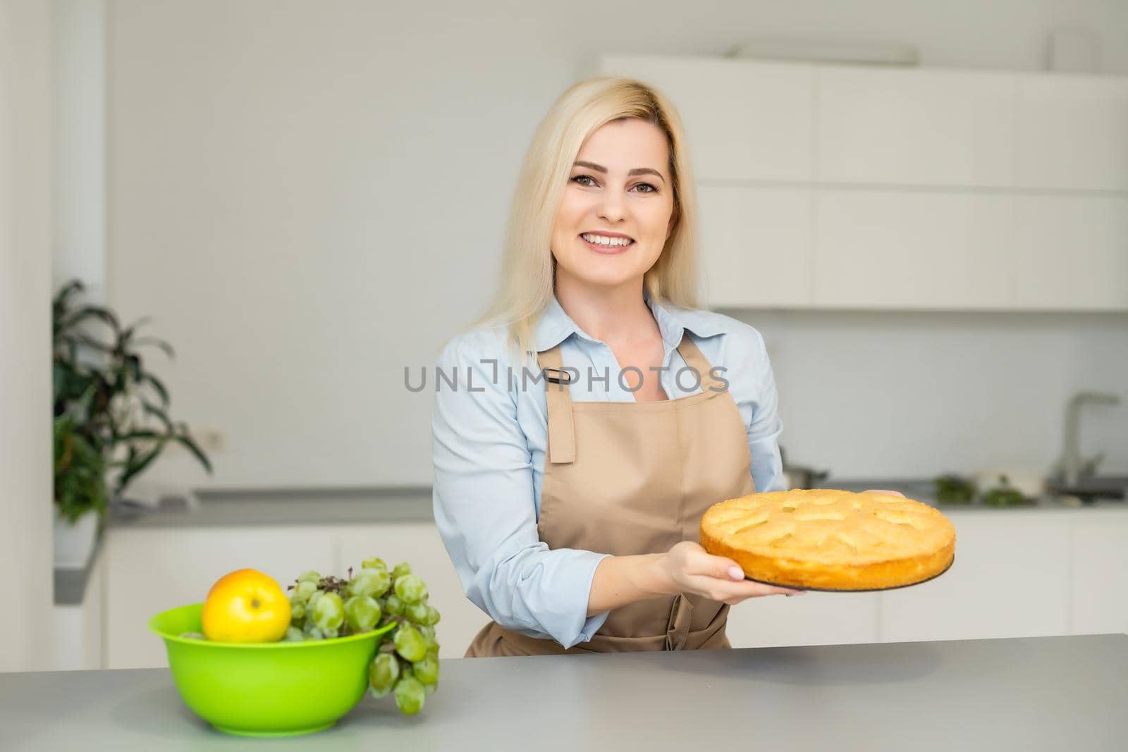 Beautiful woman holding pie in the kitchen