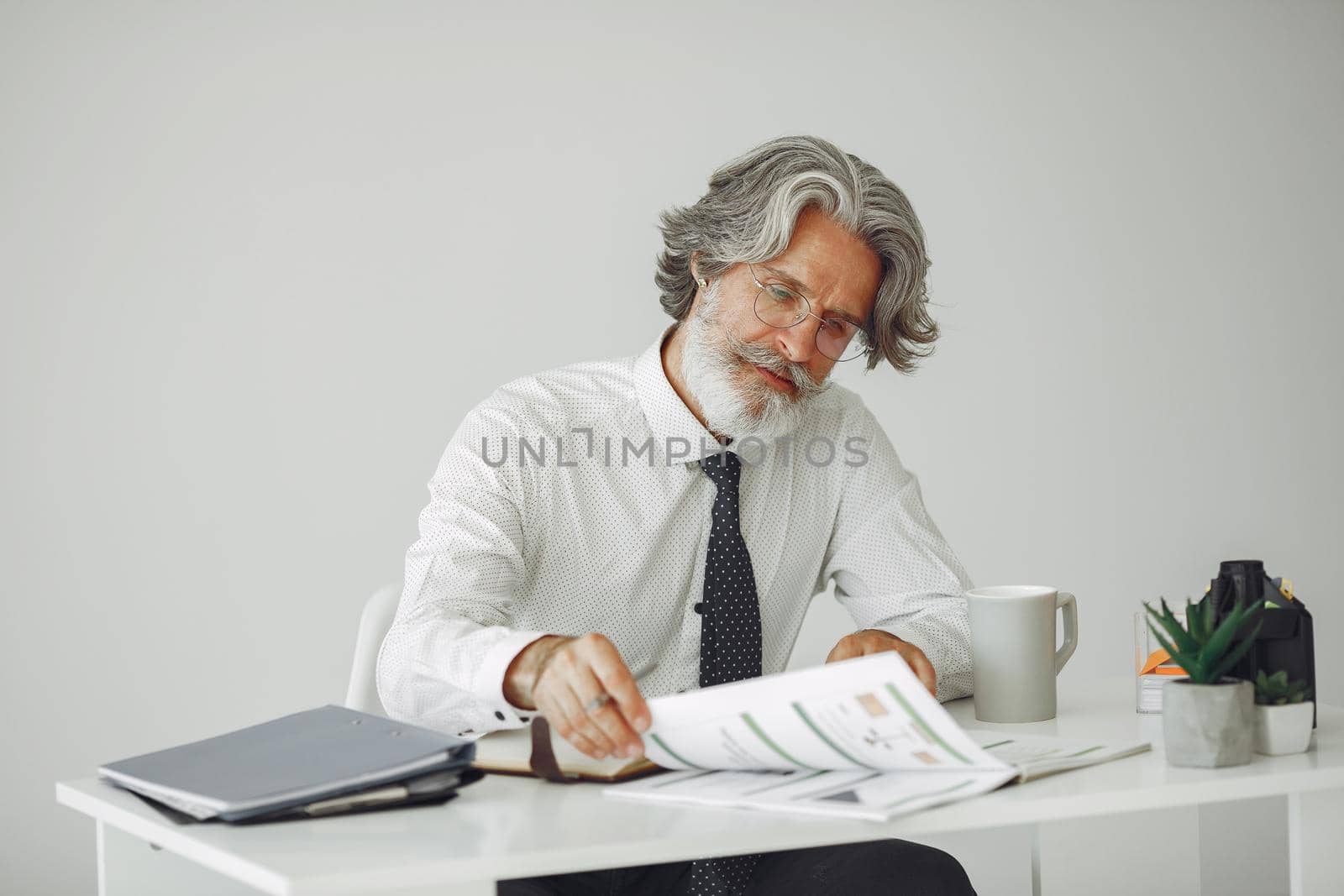 Elegant man in office. Businessman in white shirt. Man works with documents.