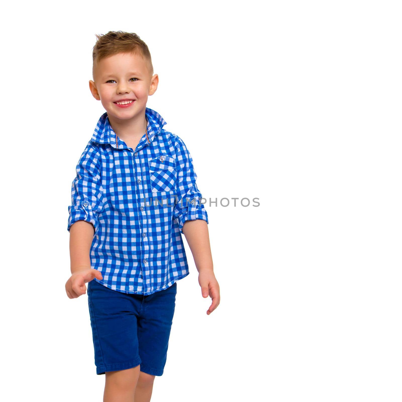 A cute little boy in a shirt and shorts. The concept of a summer family vacation, a happy childhood. Isolated on white background.