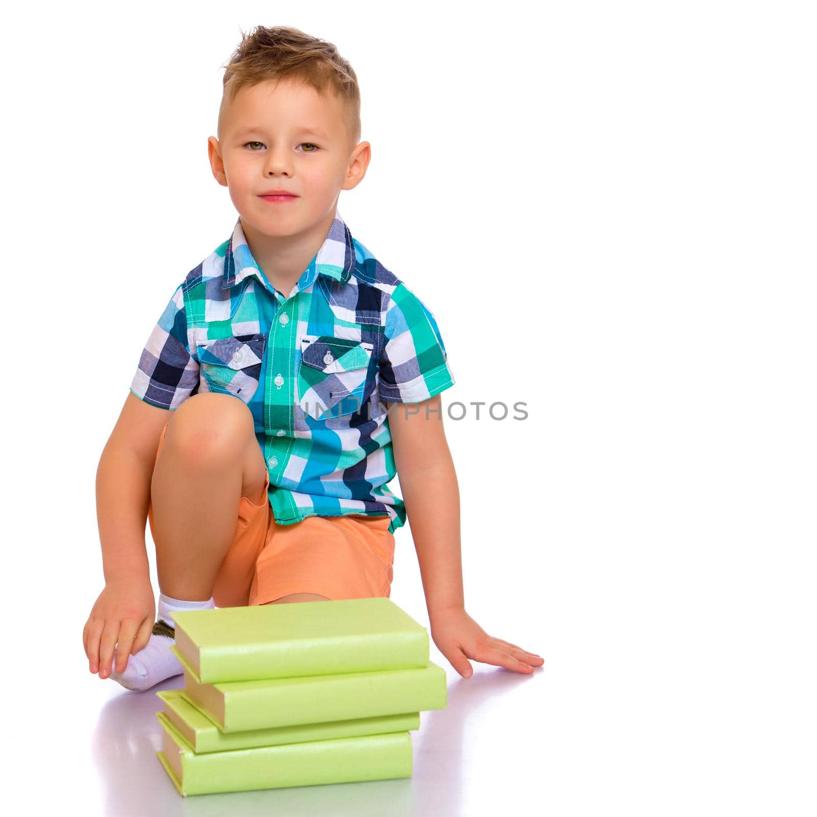 A cute little boy, a preschooler with books. The concept of education, the intellectual development of the child in the family. Isolated on white background.