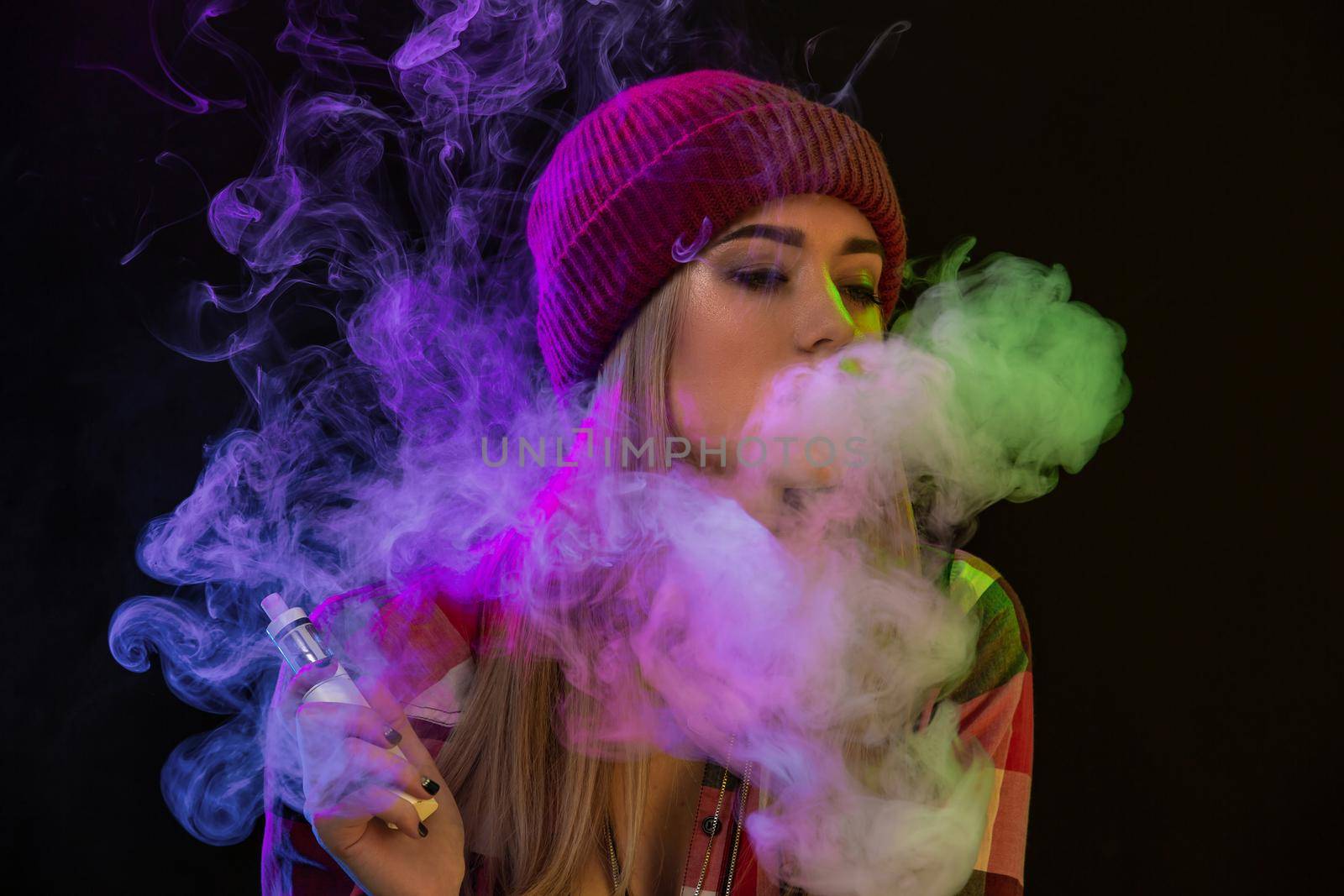 Vaping girl. Young hipster woman vape e-cig on studio on black background. Hip-hop style. Close up. Vapor concept. Vaping e-Cigarette.