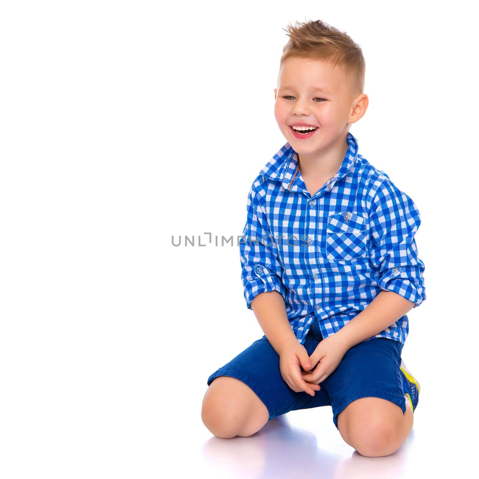 A beautiful little boy laughs fun. The concept of a happy childhood, well-being and family values. Isolated on white background.