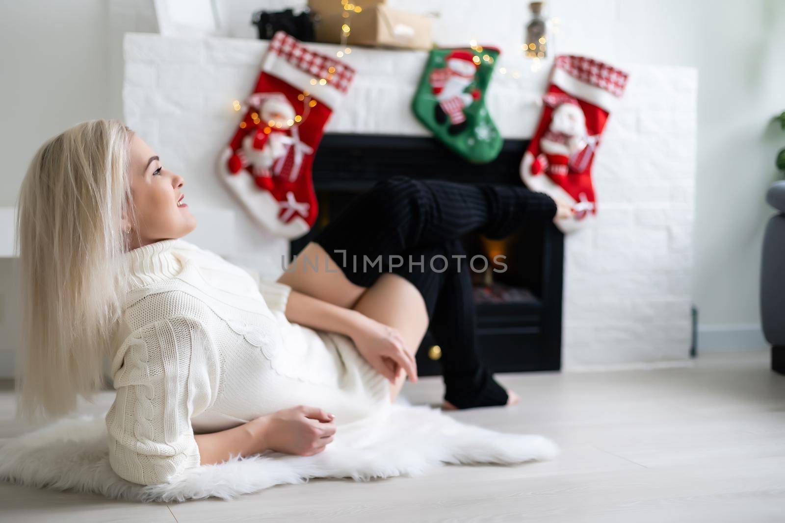 Happy young lady by the fireplace. Christmas New year concept.