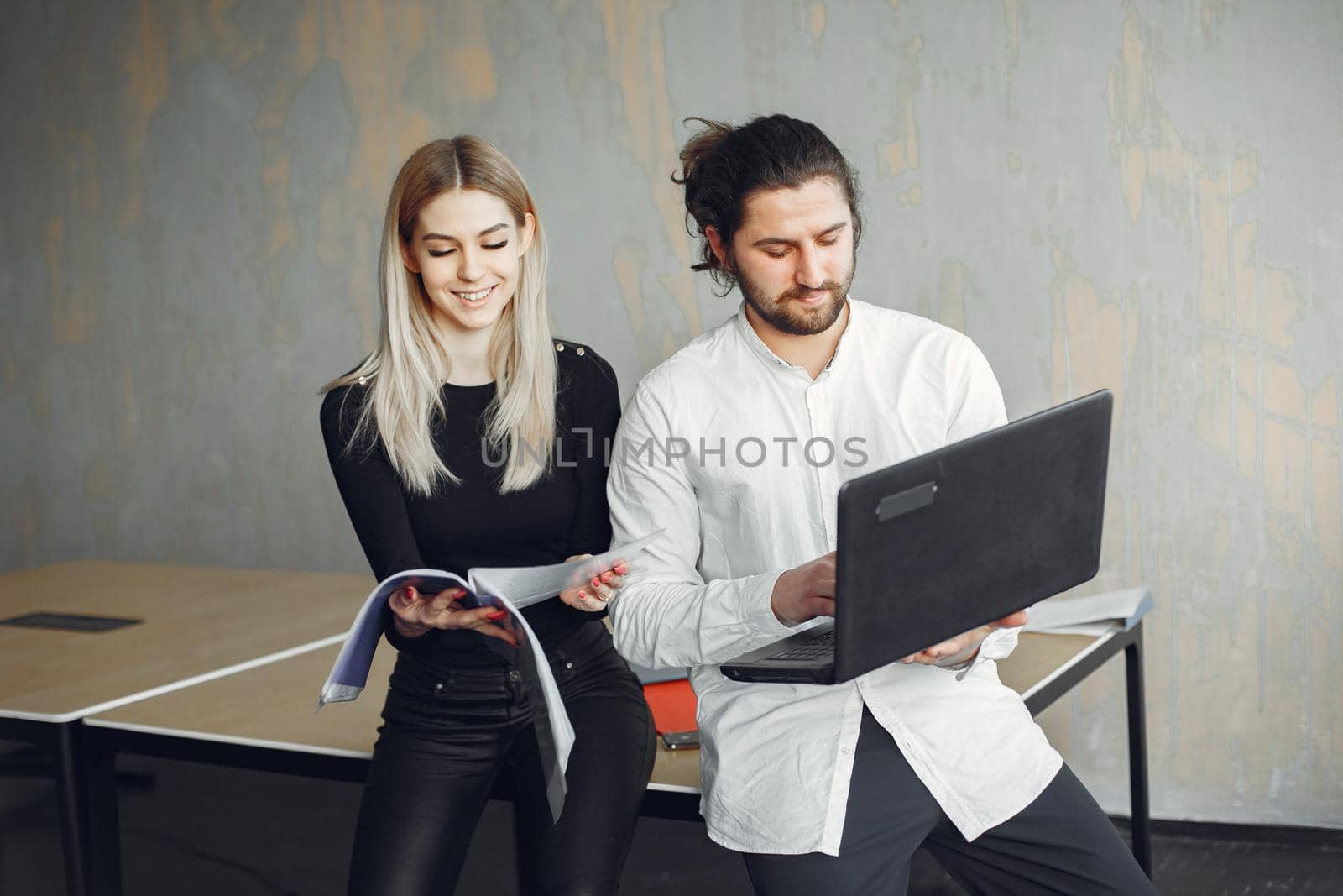 Handsome man in a white shirt. Partners together. Guy with a laptop.