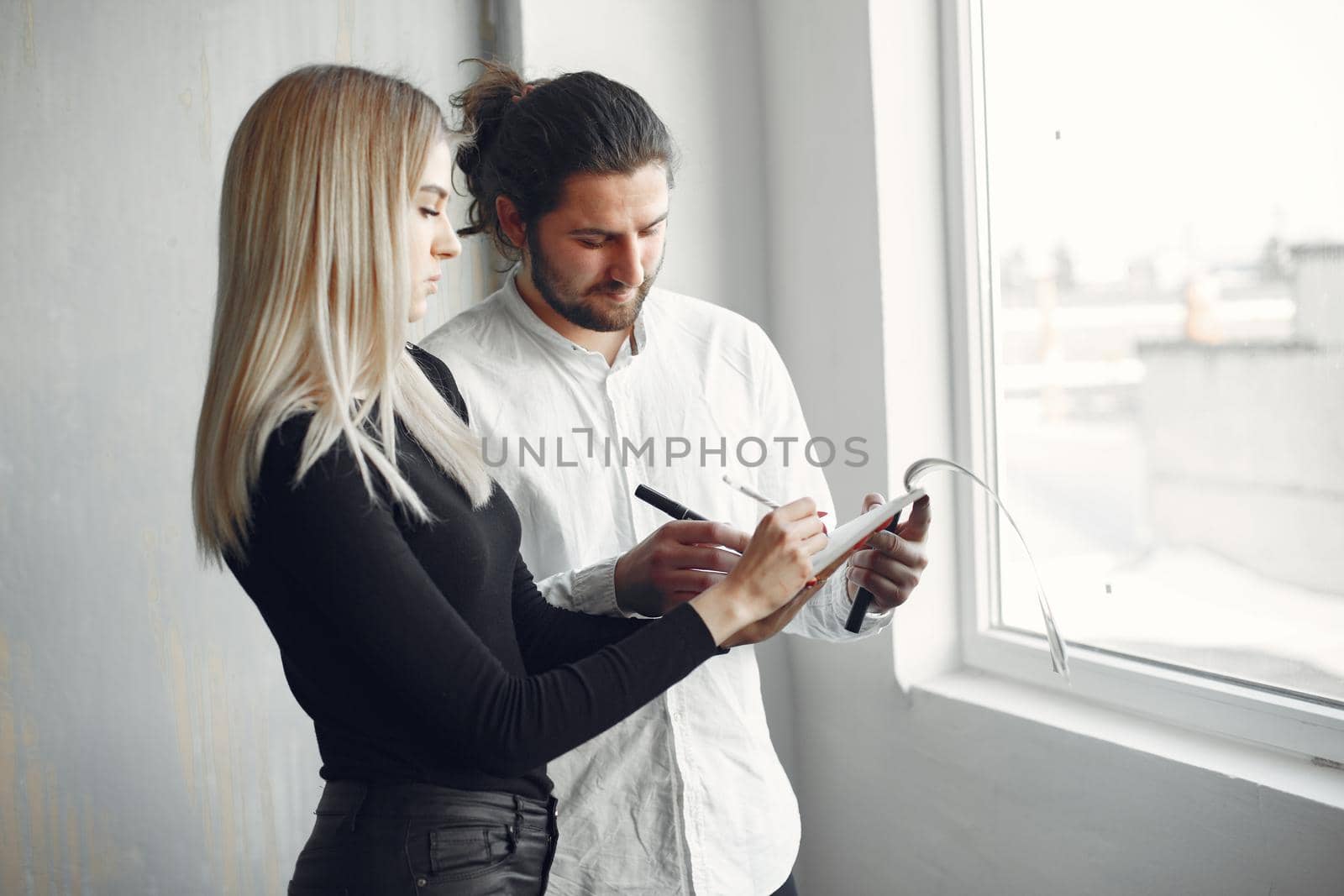 Handsome man in a white shirt. Partners together. People by the window.