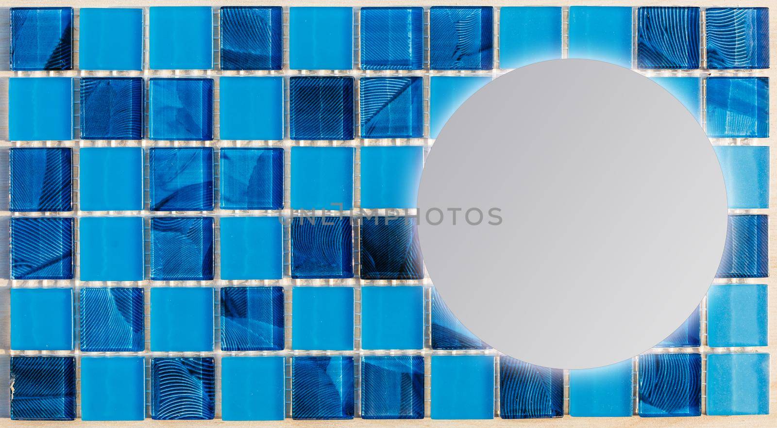 Bathroom with blue bricks wall, square wash basin and round mirror. Minimalist interior