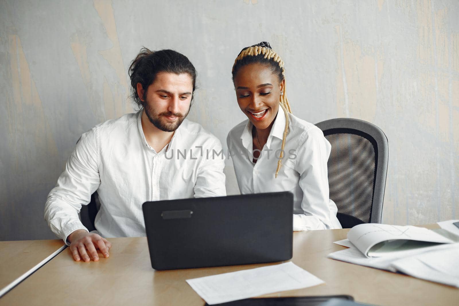 Handsome man in a white shirt. African woman with partner. Guy with a laptop.