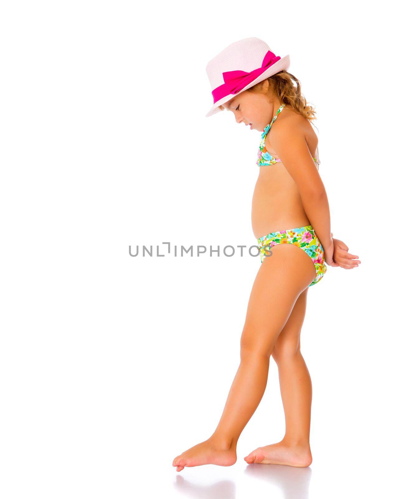 Beautiful little tanned girl in a swimsuit and a hat. The concept of summer family vacations, rest on the sea, beautiful tan. Isolated on white background.