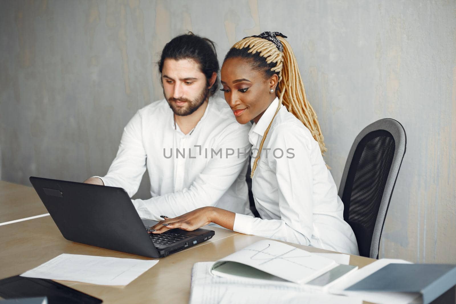 Handsome man in a white shirt. African woman with partner. Guy with a laptop.