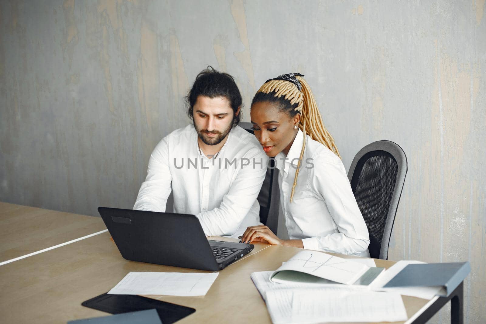 Handsome man in a white shirt. African woman with partner. Guy with a laptop.