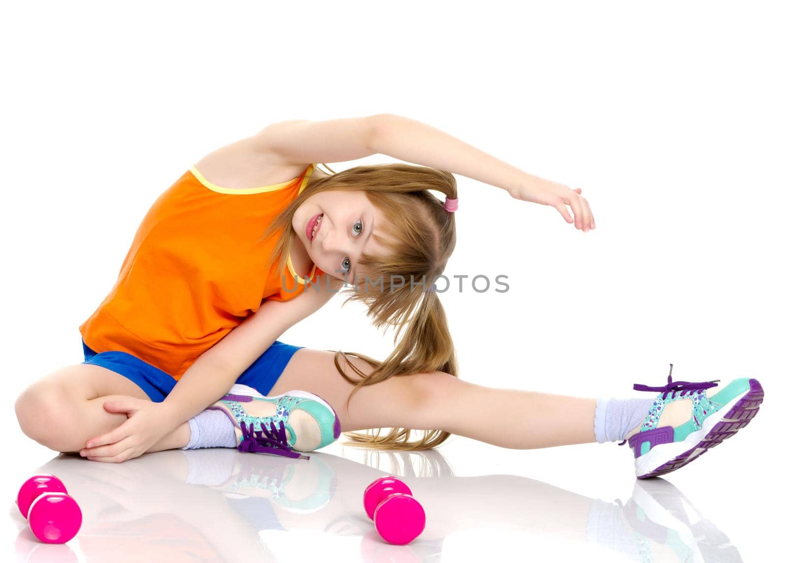 A nice little girl is performing gymnastic exercises. Concept of a healthy lifestyle, sport and fitness. Isolated on white background.