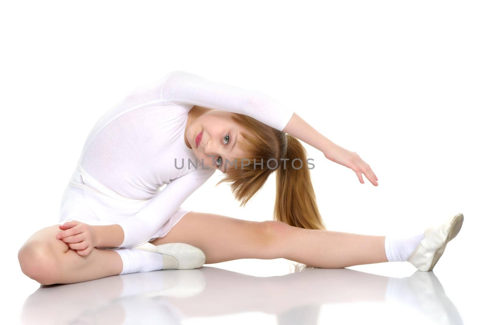 A nice little girl is performing gymnastic exercises. Concept of a healthy lifestyle, sport and fitness. Isolated on white background.