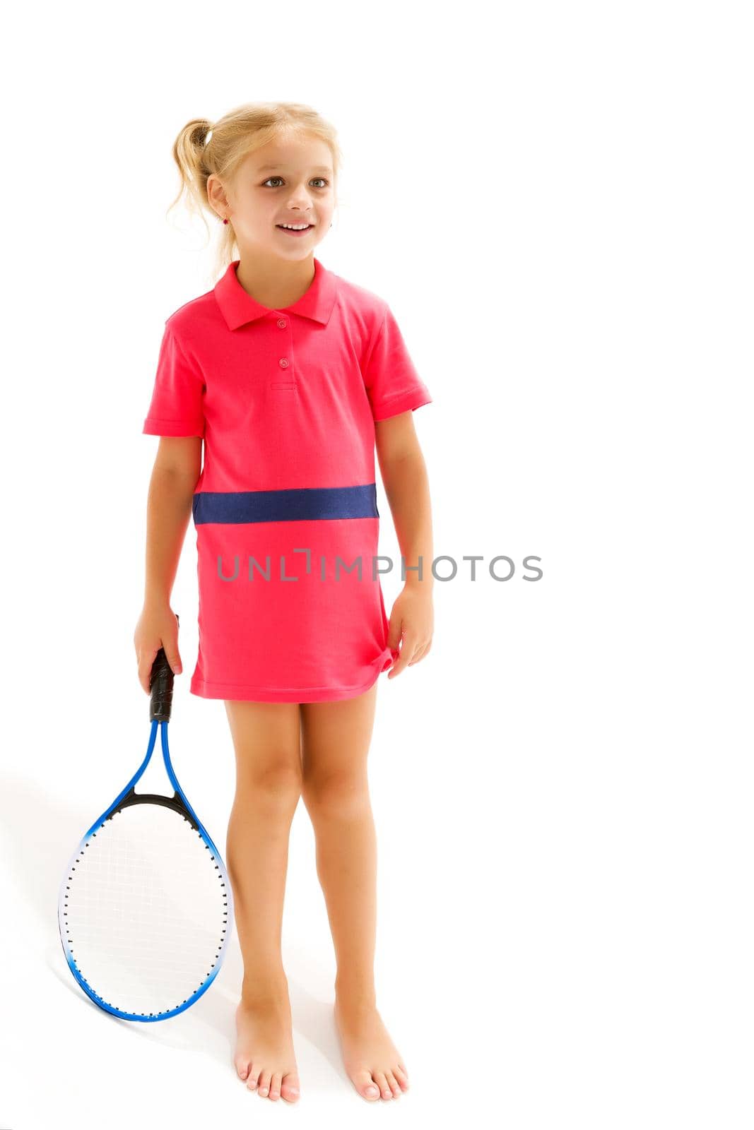 Happy playful girl smiling on the tennis court with a racket. Little girl with a tennis racket in a sports club. Active exercises for children. Training for a small child. The child learns to play. Isolated on white background.