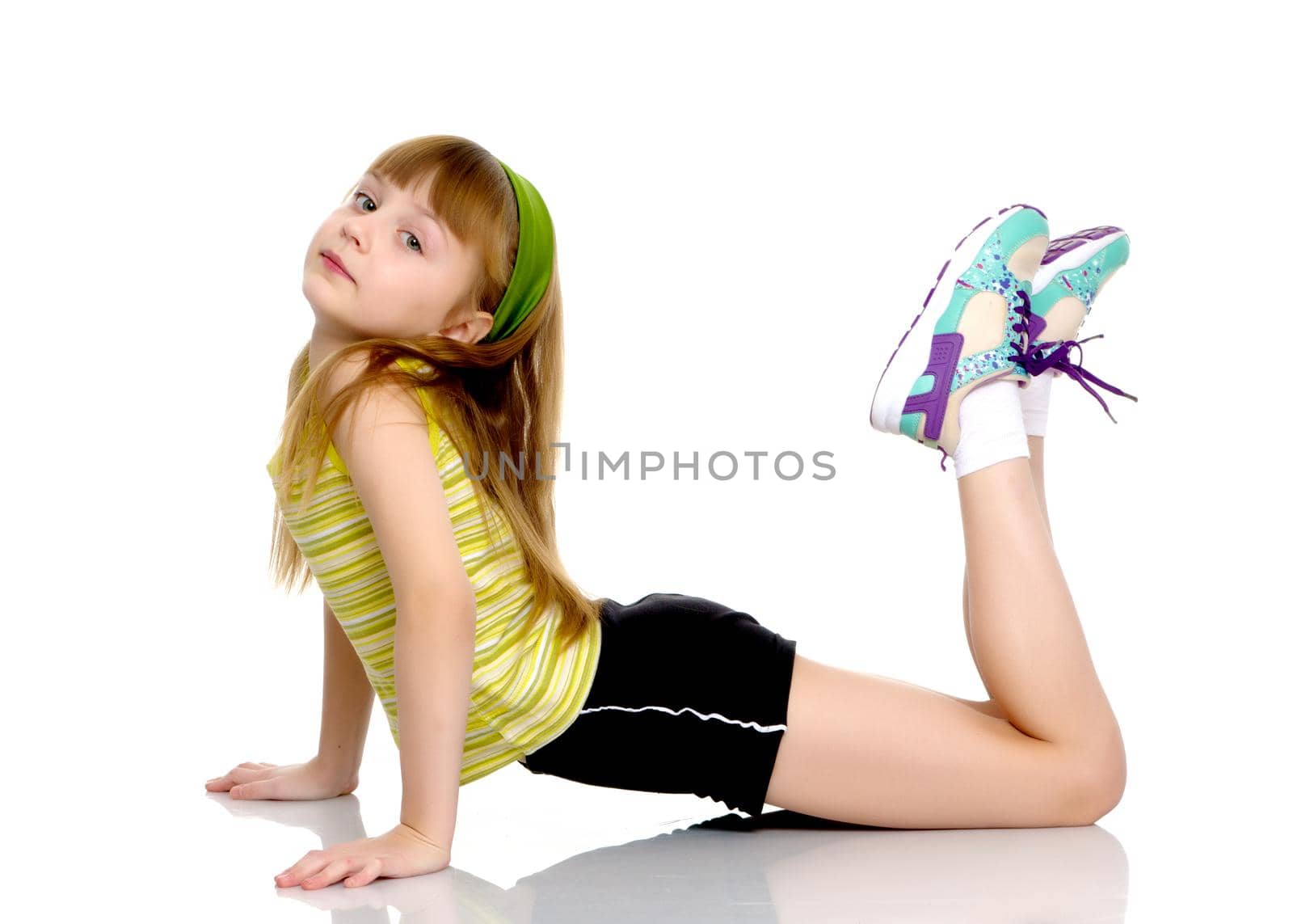 A nice little girl is performing gymnastic exercises. Concept of a healthy lifestyle, sport and fitness. Isolated on white background.