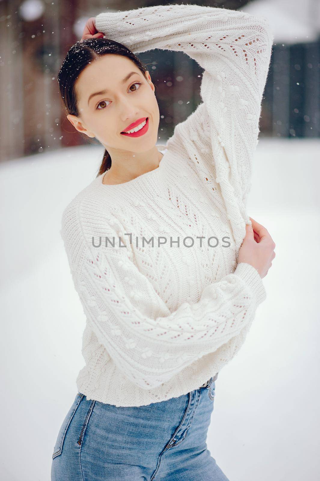 Young girl in a white sweater standing in a winter park by prostooleh