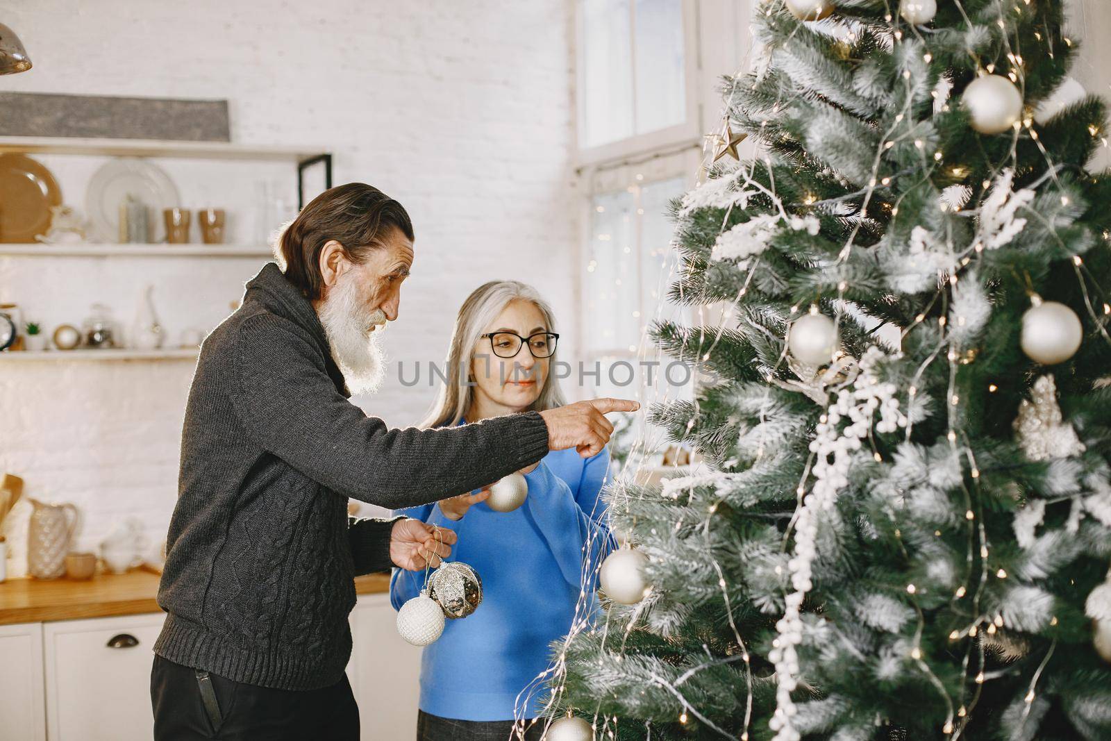 Age and people concept . Senior couple at home. Woman in a blue knited sweater.