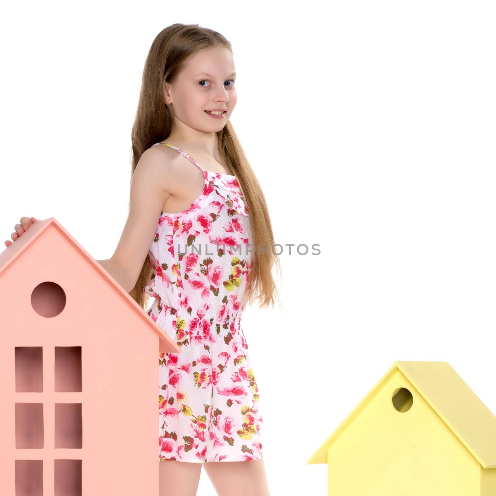 Little girl is playing with wooden houses. by kolesnikov_studio