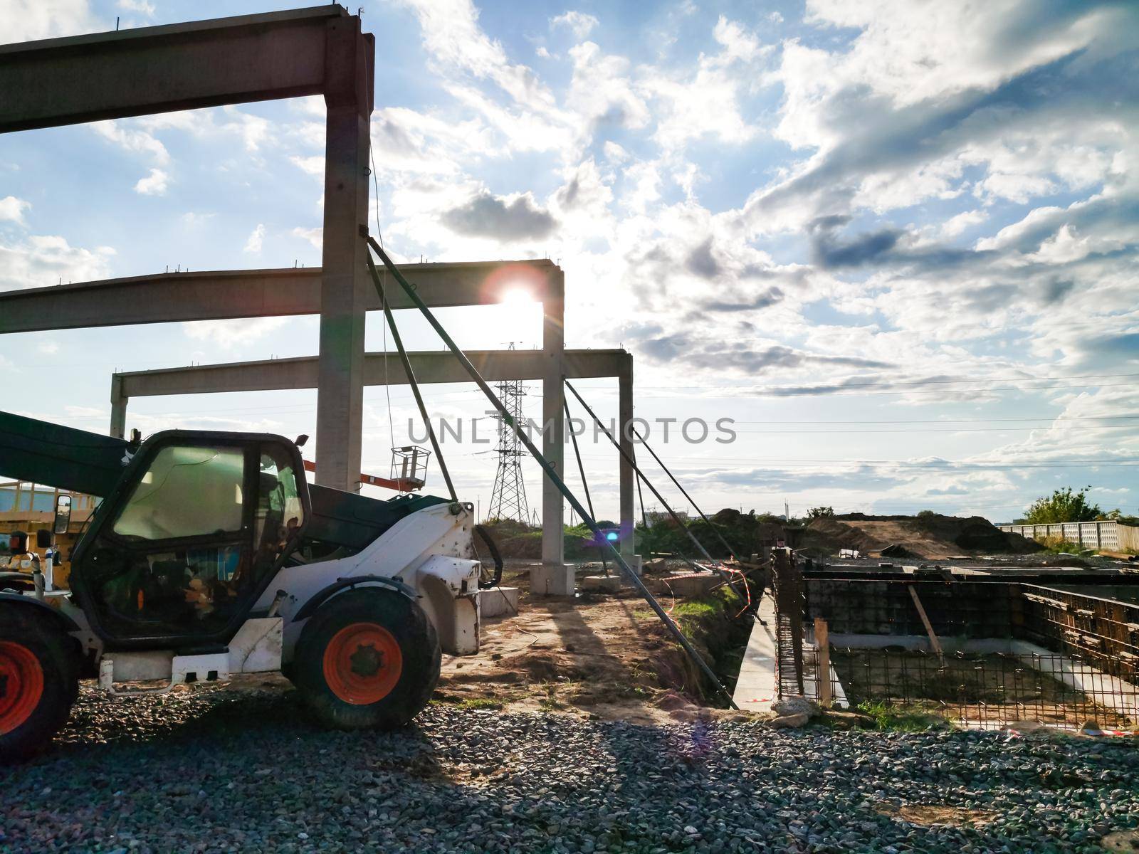 excavator on new construction site, in the background the blue sky and sun