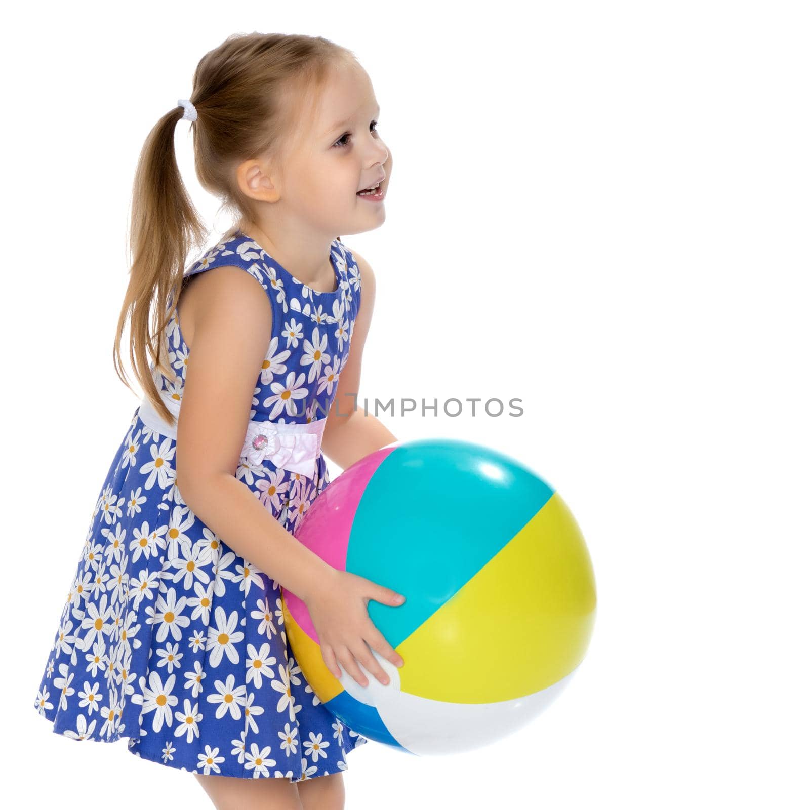 A nice little girl is playing with a big inflatable ball. The concept of a happy childhood, family recreation in nature, fitness and exercise. Isolated on white background.