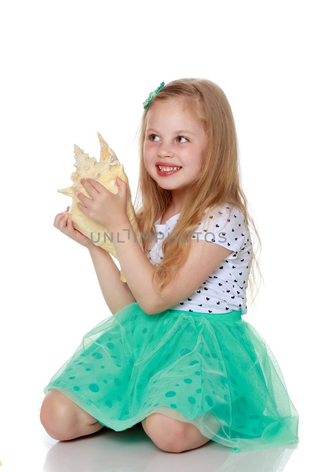 A little girl with a sea shell. The concept of a family vacation at sea, ecology. Isolated on white background.