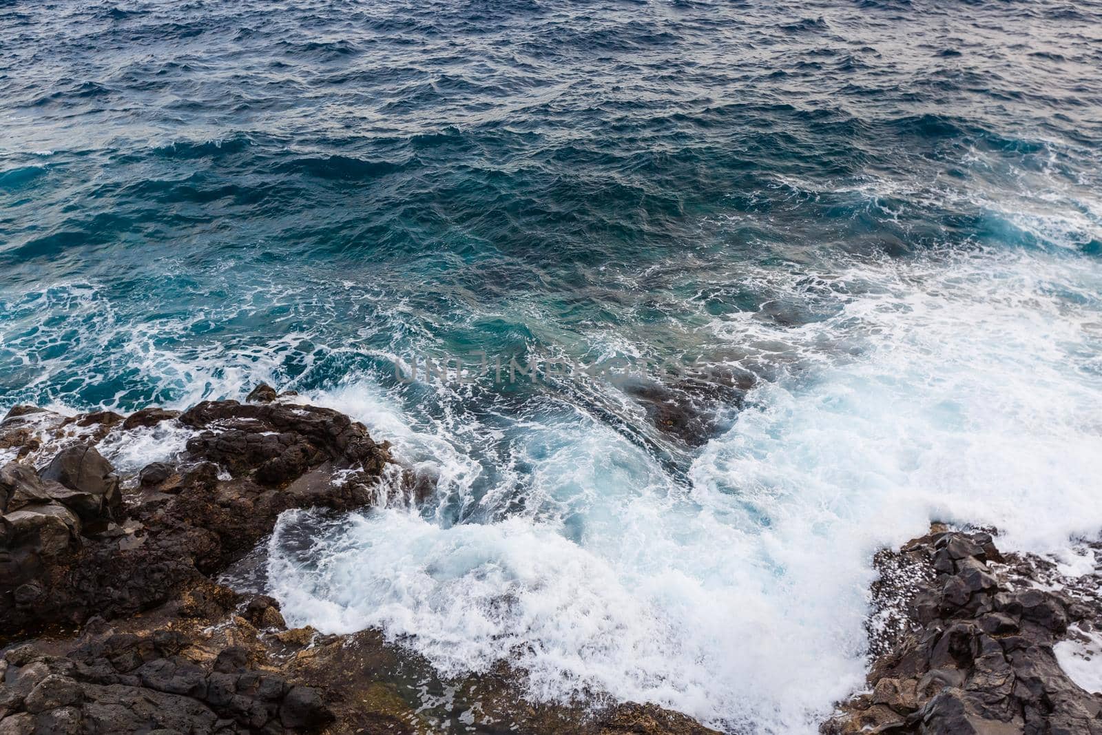 ocean waves hit and crash against stones