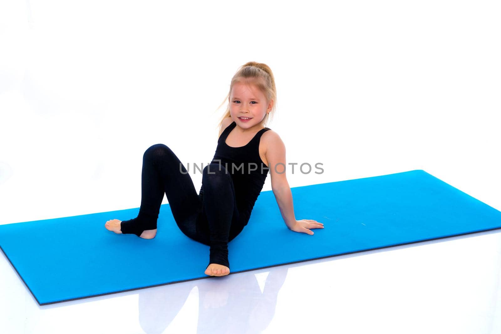 A gymnast girl prepares for the exercise. The concept of childhood and sport, a healthy lifestyle. Isolated on white background.