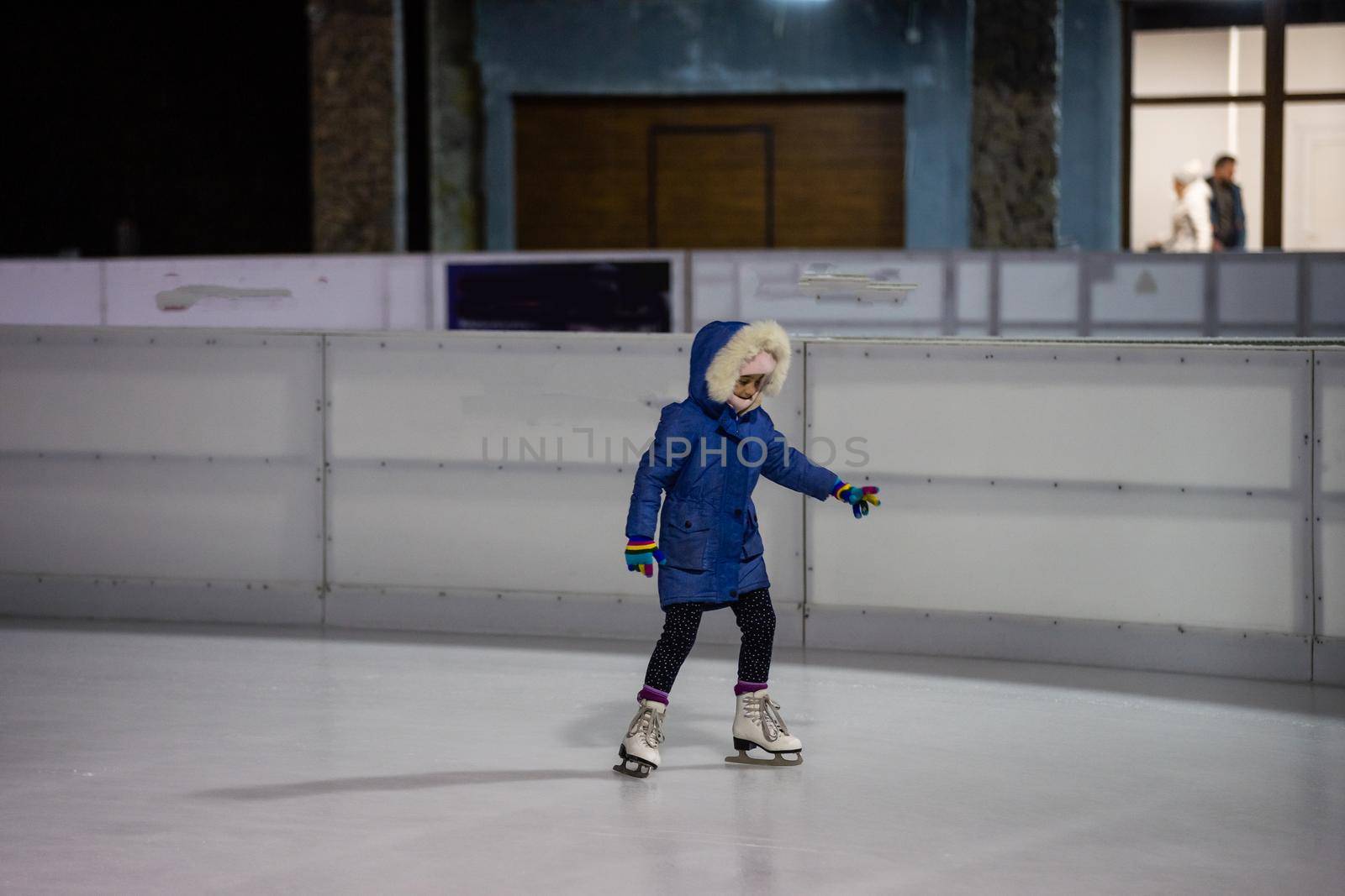 Little girl learning to skate at the rink.