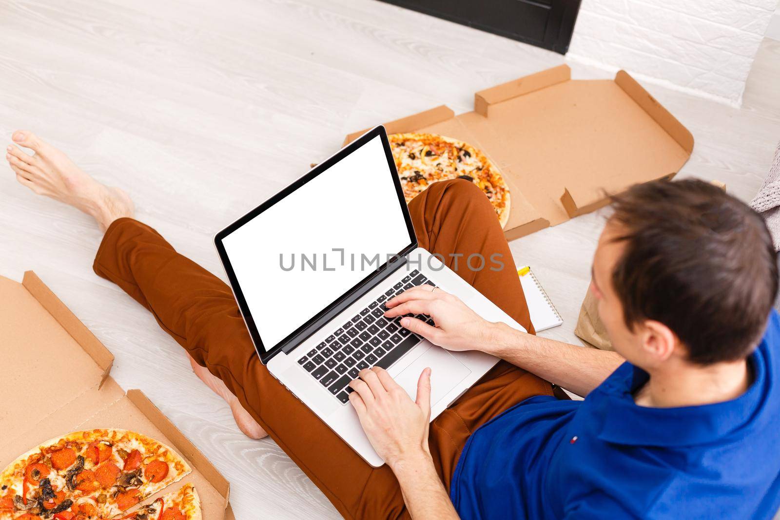 Back view of male person sitting front open laptop computer with blank empty screen for your information or content, modern businessman working in internet