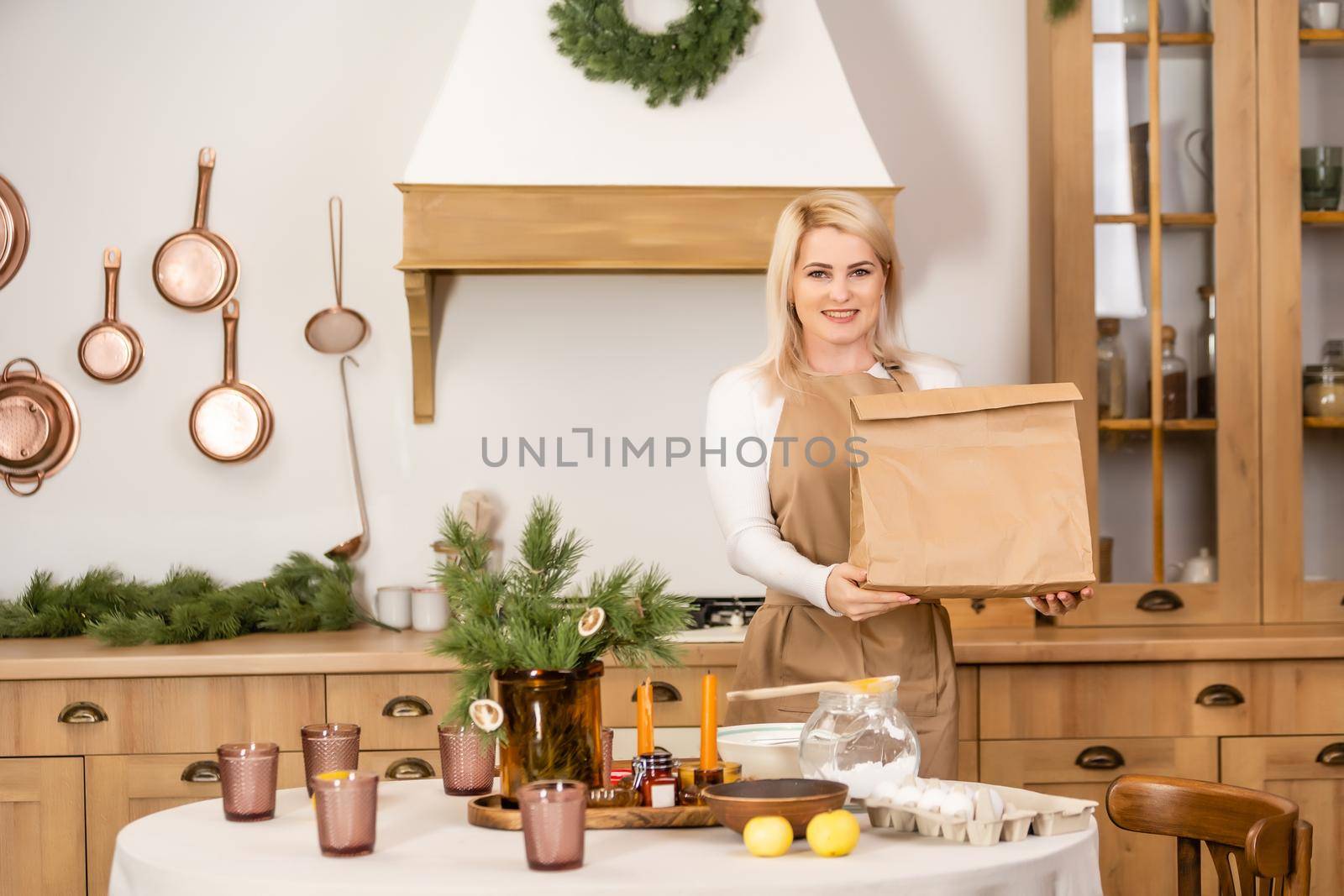 Young beautiful woman holding take away paper bag from delivery