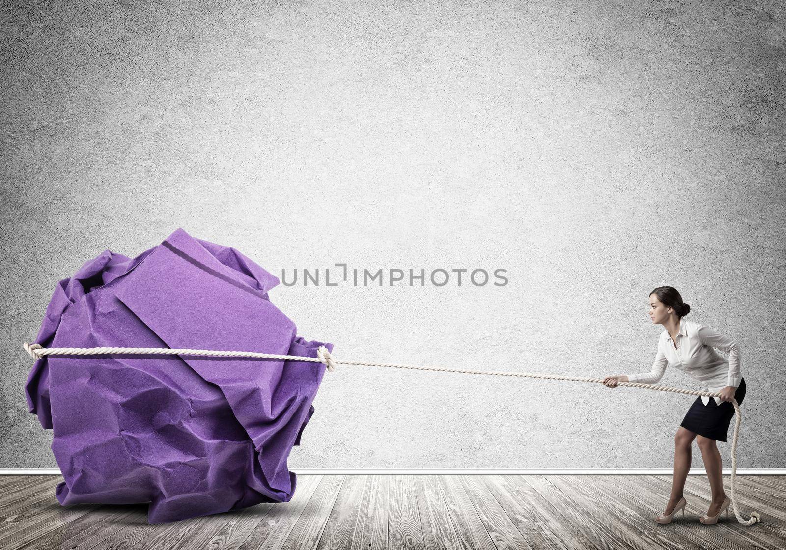 Young woman making huge paper ball move