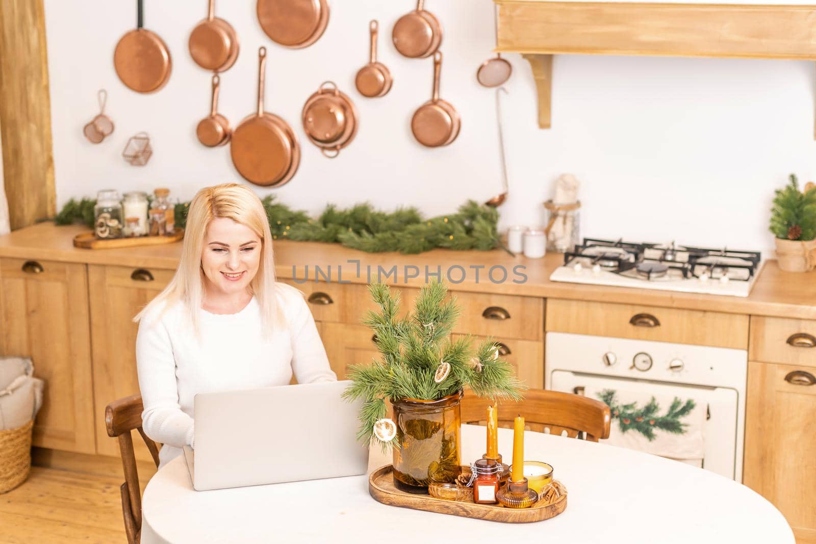 Smiling woman sitting surfing the internet on a laptop computer at home,