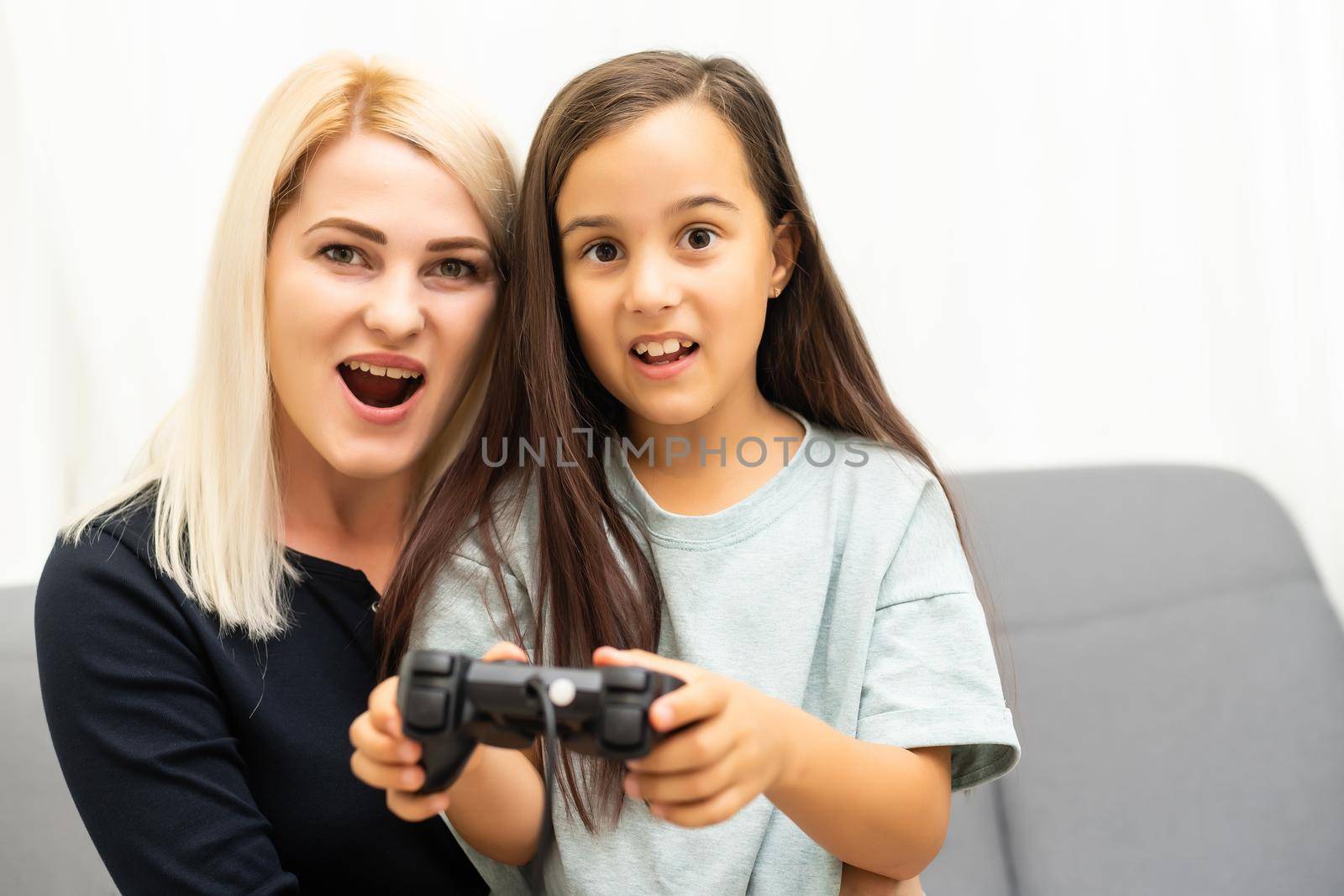 happy family together. mother and her child girl playing video games. family relax. by Andelov13