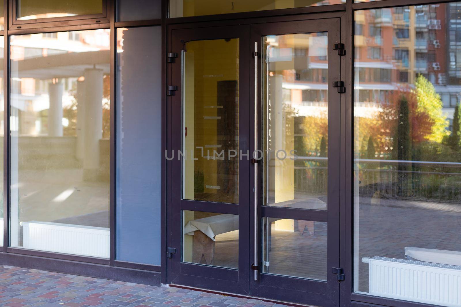 The front door of a office block, reflecting buildings in the glass.