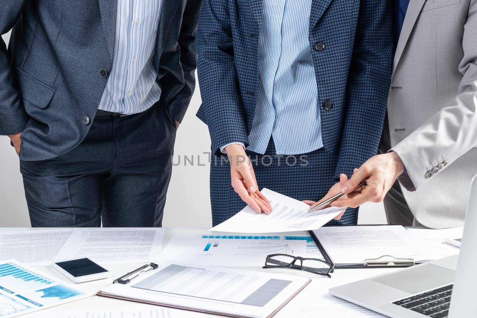 Corporate teamwork concept with businessmen. Business people meeting in conference room. Idea presentation, analysis and planning. Office desk with financial charts. Collaboration and conversation.
