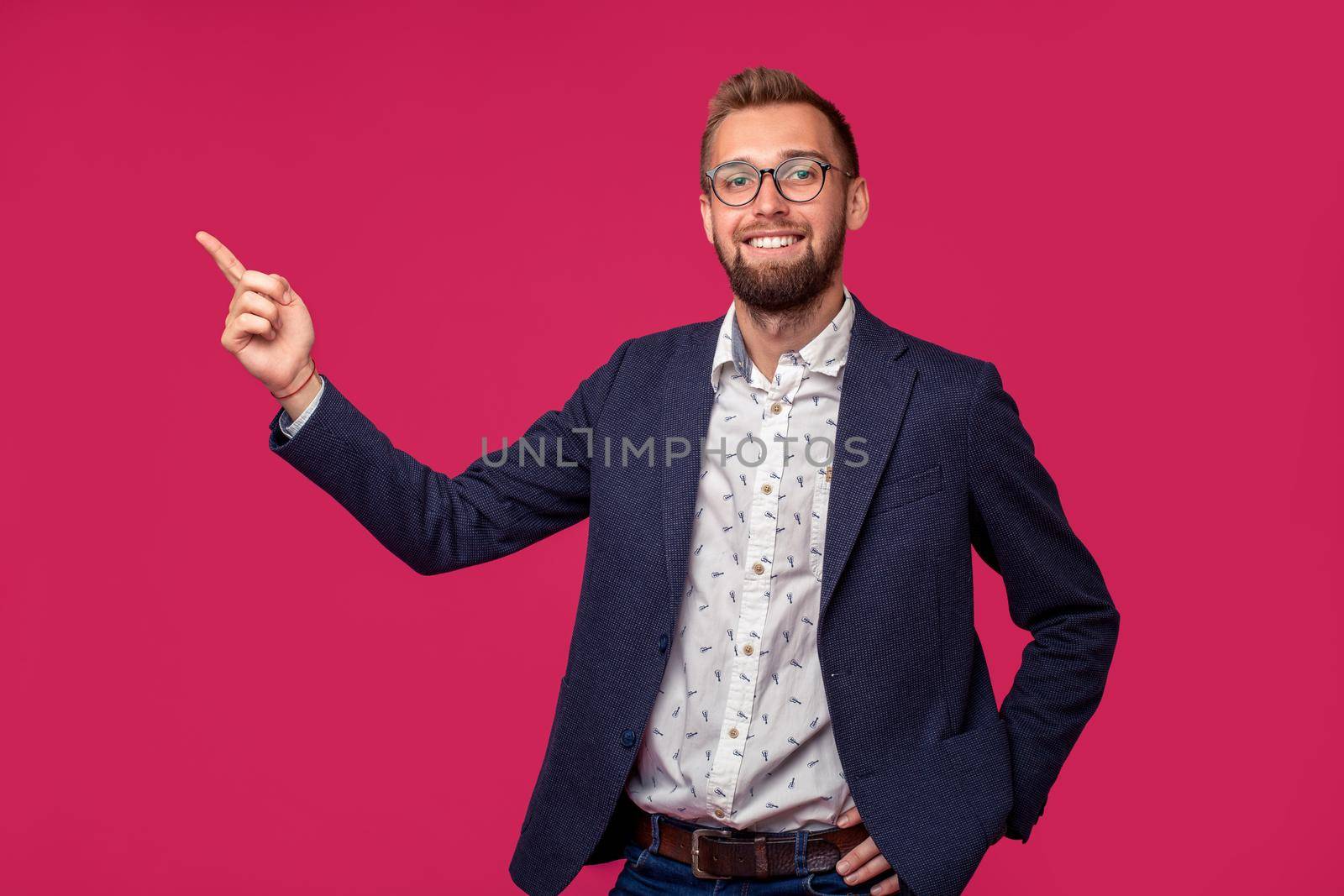 Portrait view of an attractive happy businessman with glasses on a pink background. Studio shot. Copy space