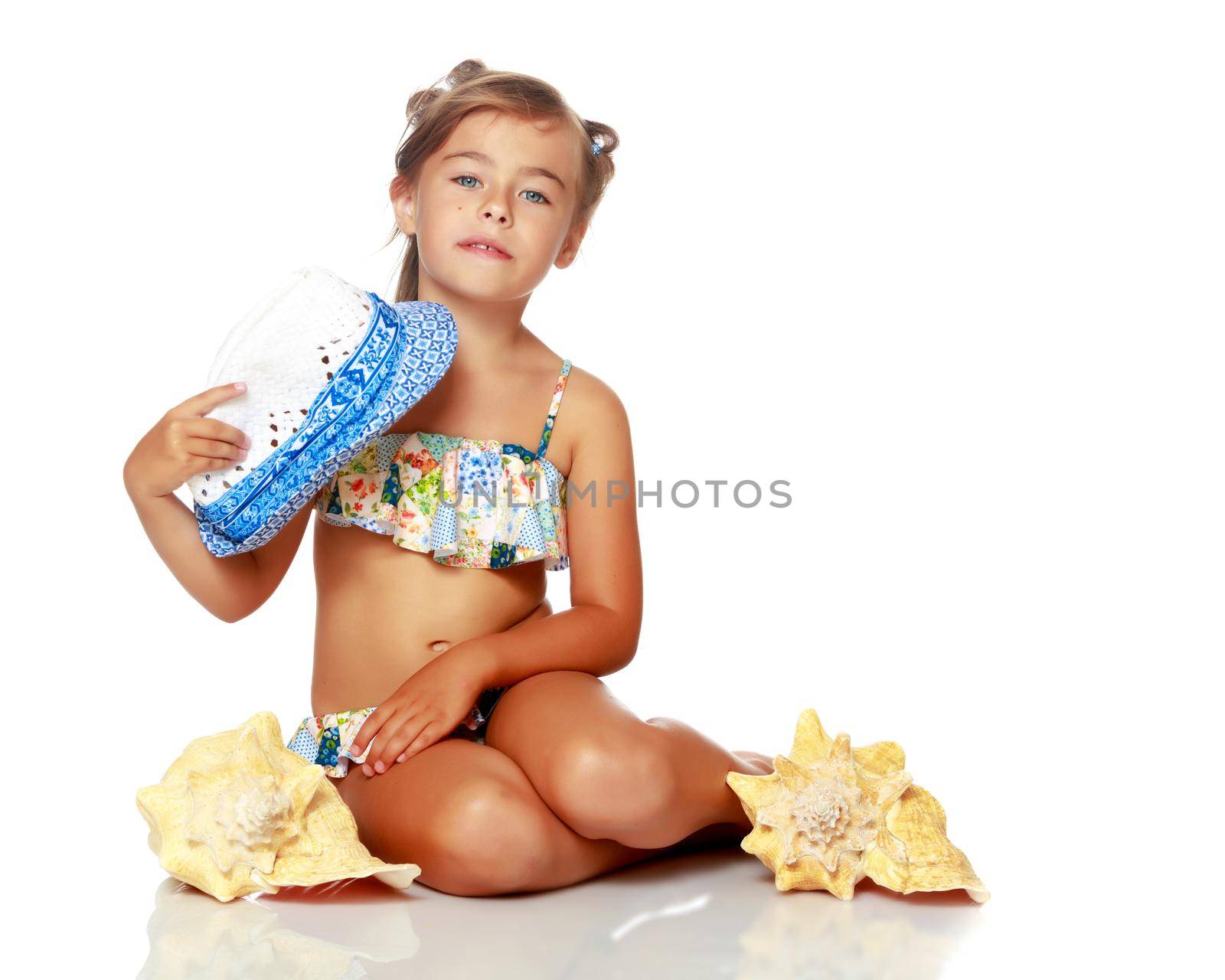 Little girl in a swimsuit with a seashell by kolesnikov_studio