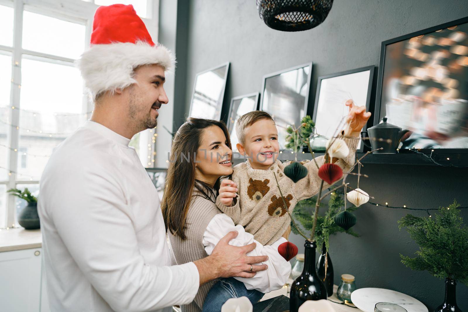 Happy family making Christmas decorations at home together by Fabrikasimf